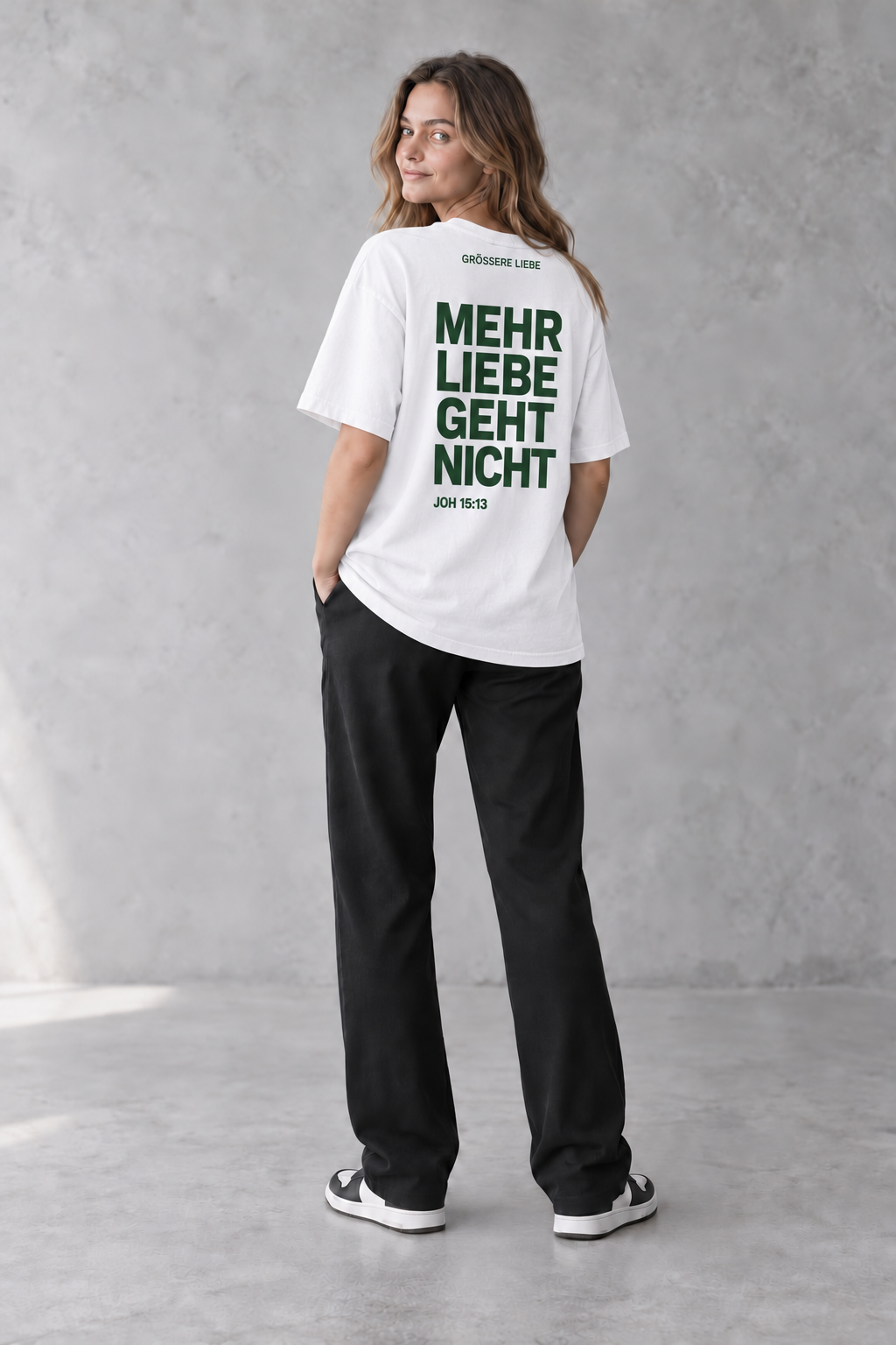 Weibliches Model mit weißem GRÖSSERE LIEBE Signature-T-Shirt und Johannes 15:13 von hinten